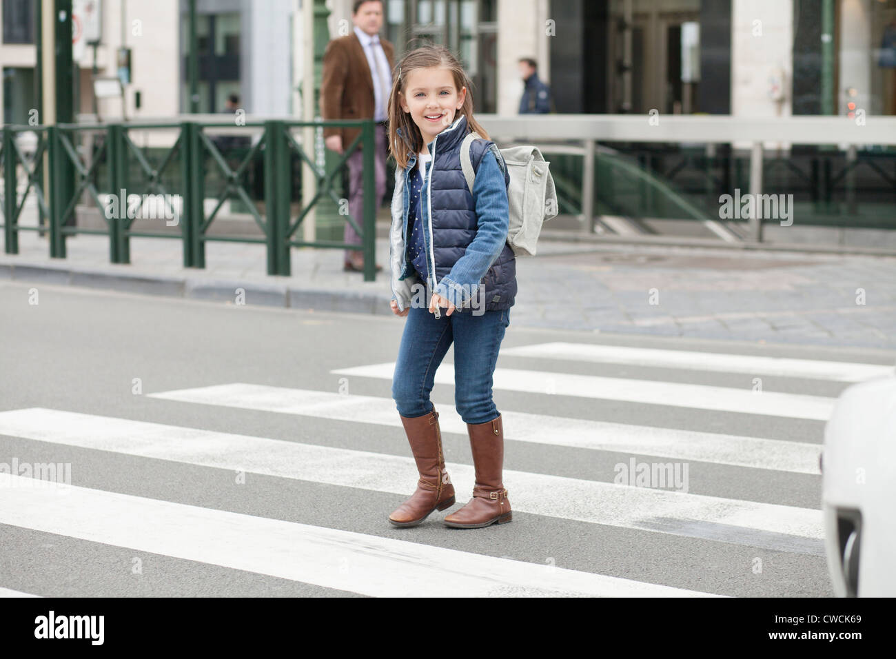 Schoolgirl crossing a road Stock Photo