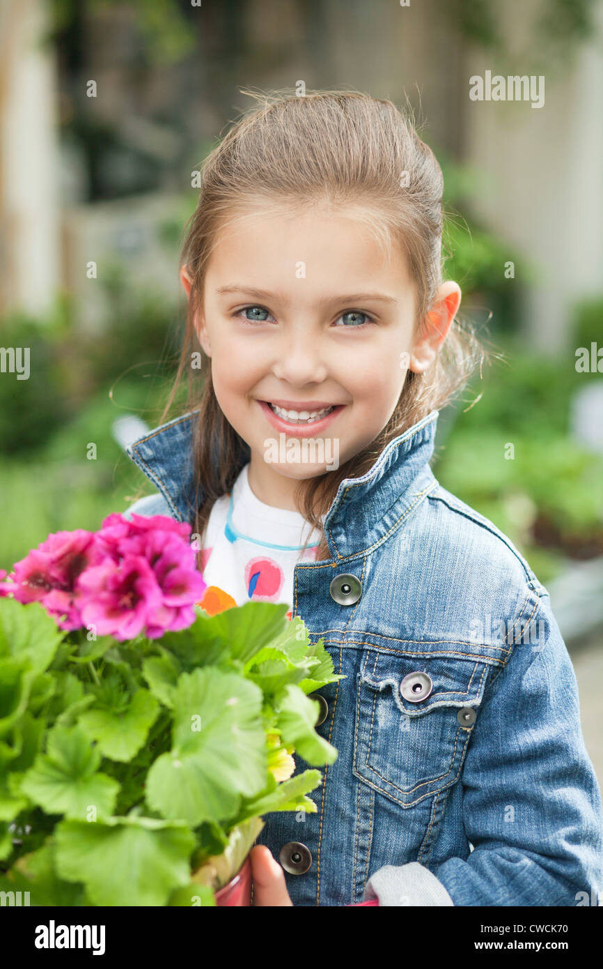 Portrait of a girl holding a potted plant Stock Photo - Alamy