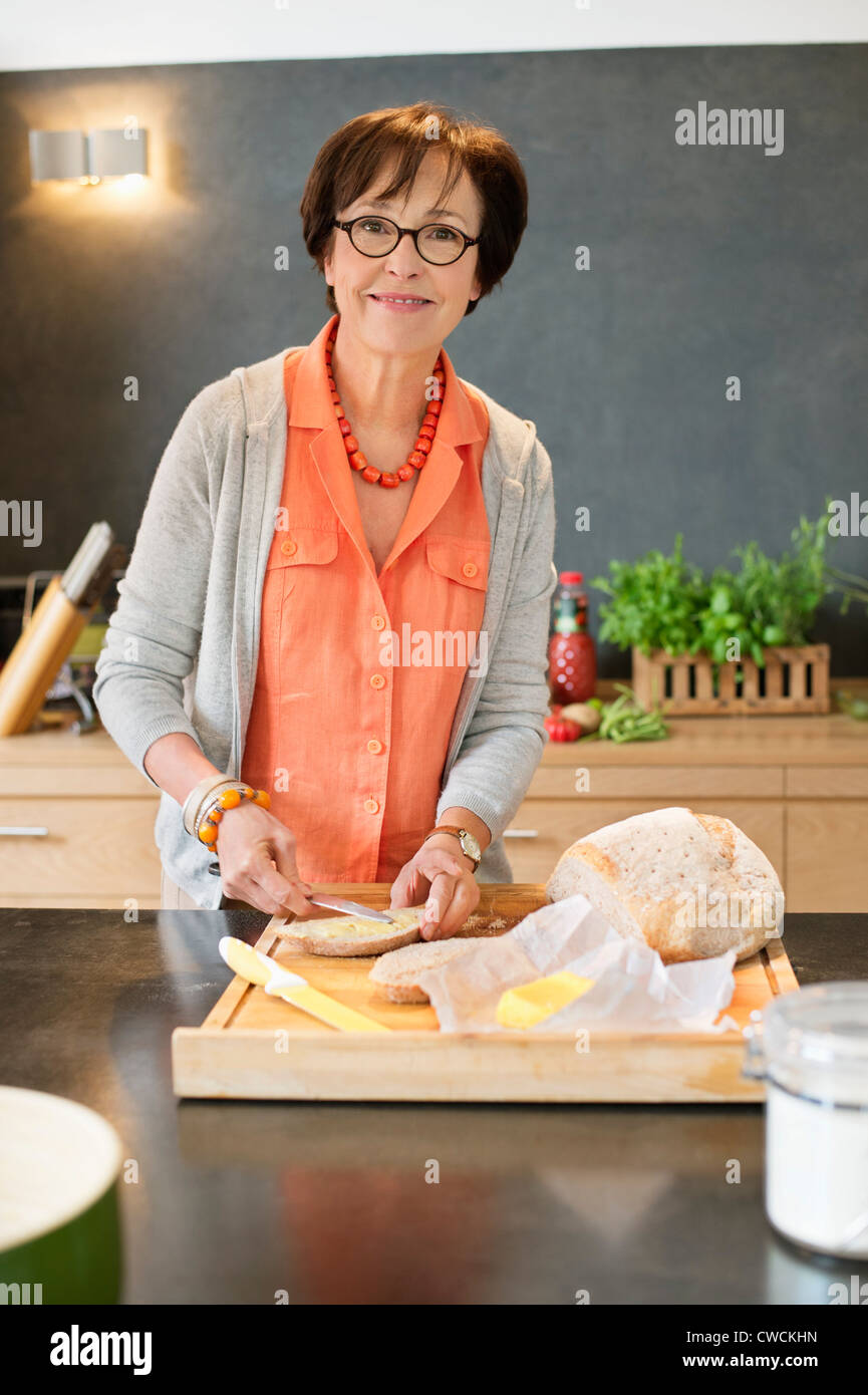 Woman applying butter on bread Stock Photo - Alamy