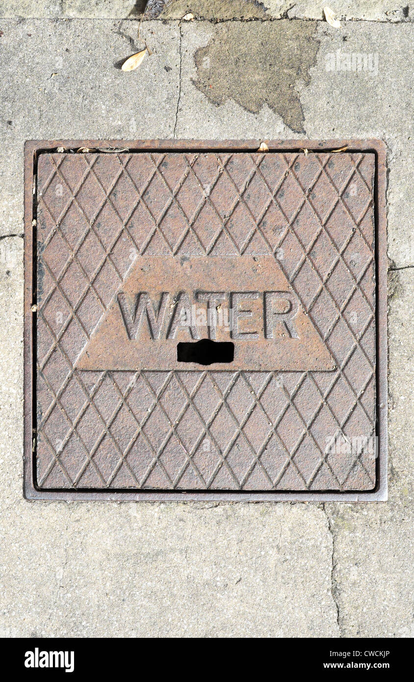 Water main cast iron tap cover set into the pavement Stock Photo Alamy