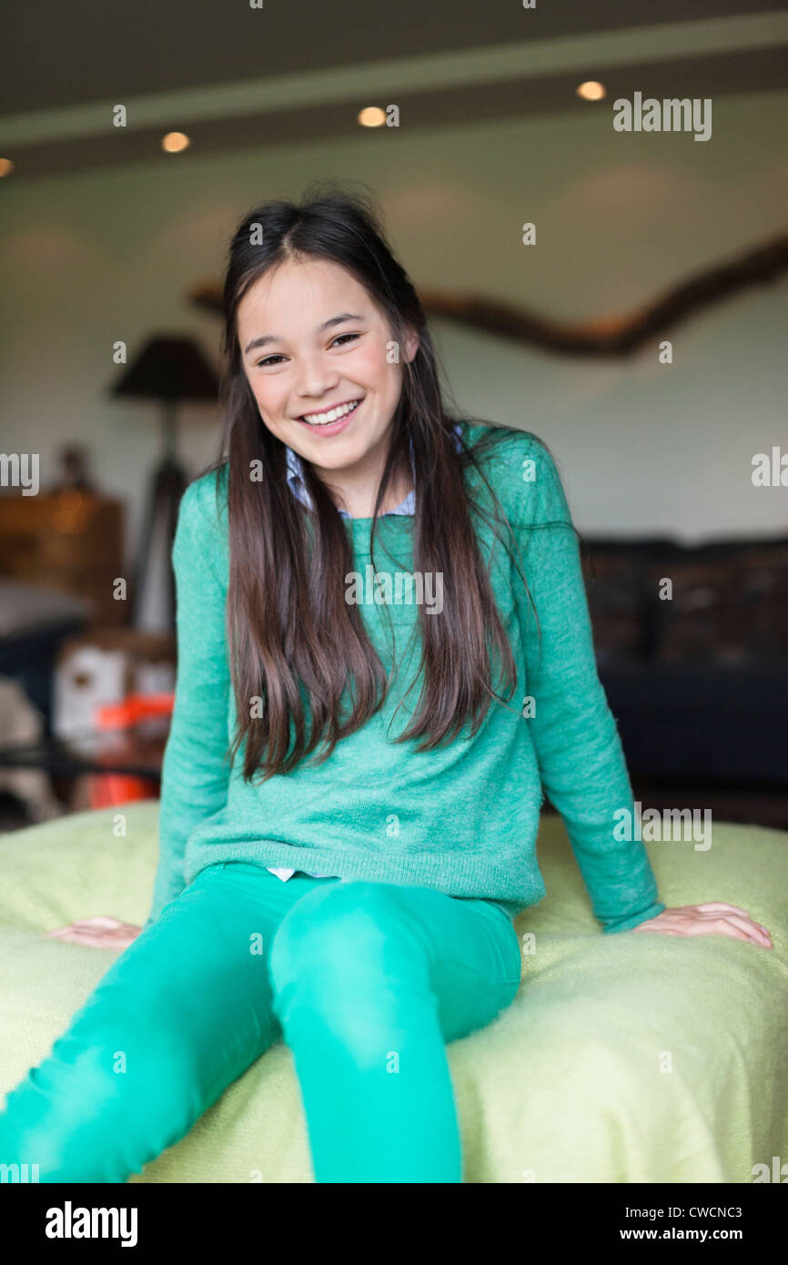Portrait of a girl sitting on bed Stock Photo - Alamy