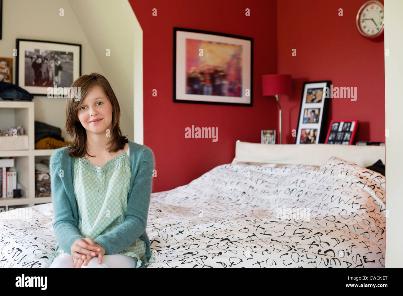Portrait of a girl sitting on the bed and smiling Stock Photo - Alamy