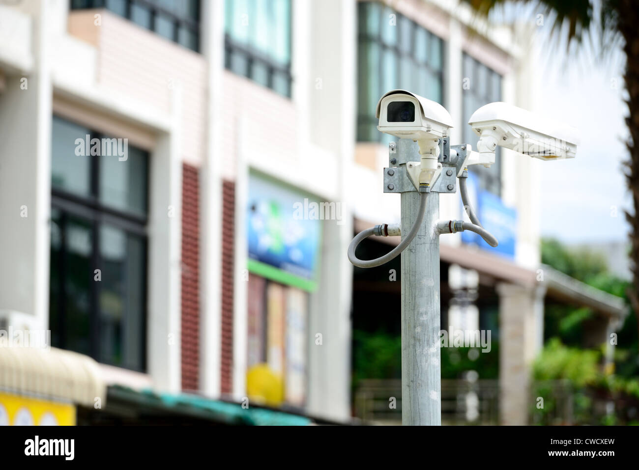 security camera on the pole next to the building Stock Photo