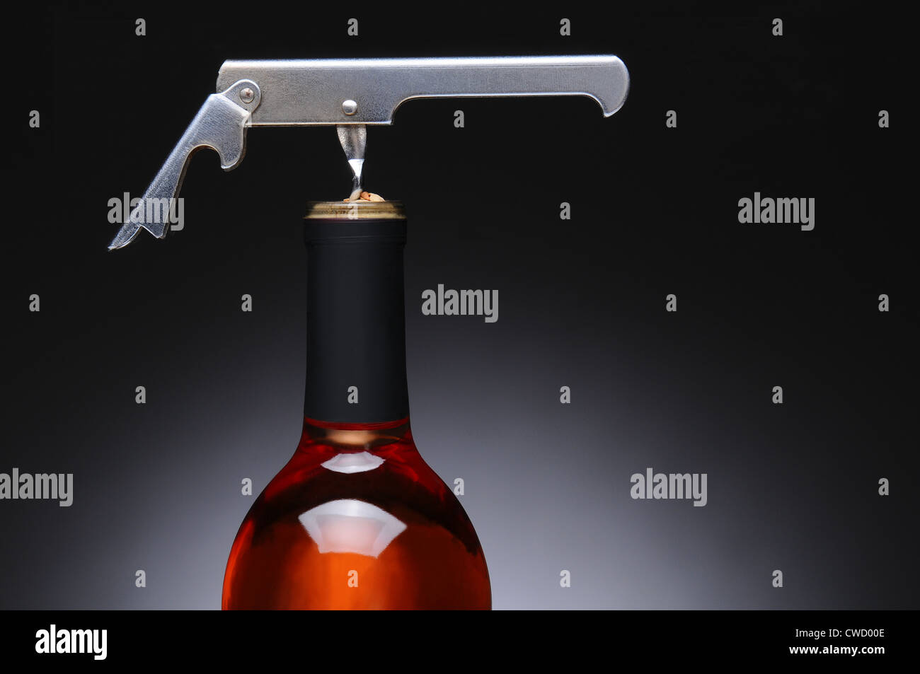 Closeup of a metal waiters corkscrew in a red wine bottle. Horizontal