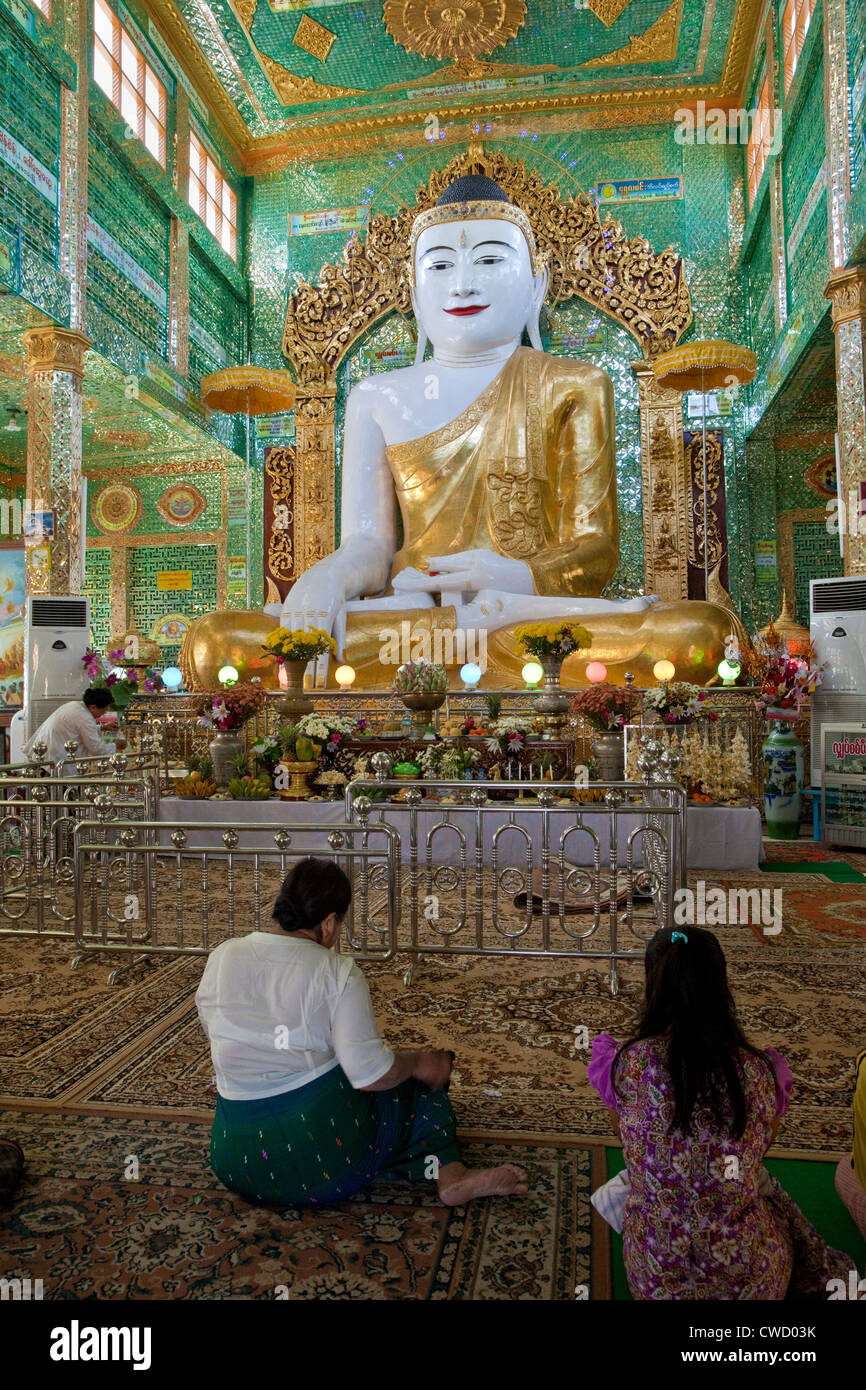 Myanmar, Burma. Buddha Statue and Worshipers, near Mandalay. Soon U Ponya Shin Pagoda, Sagaing Hill. Stock Photo