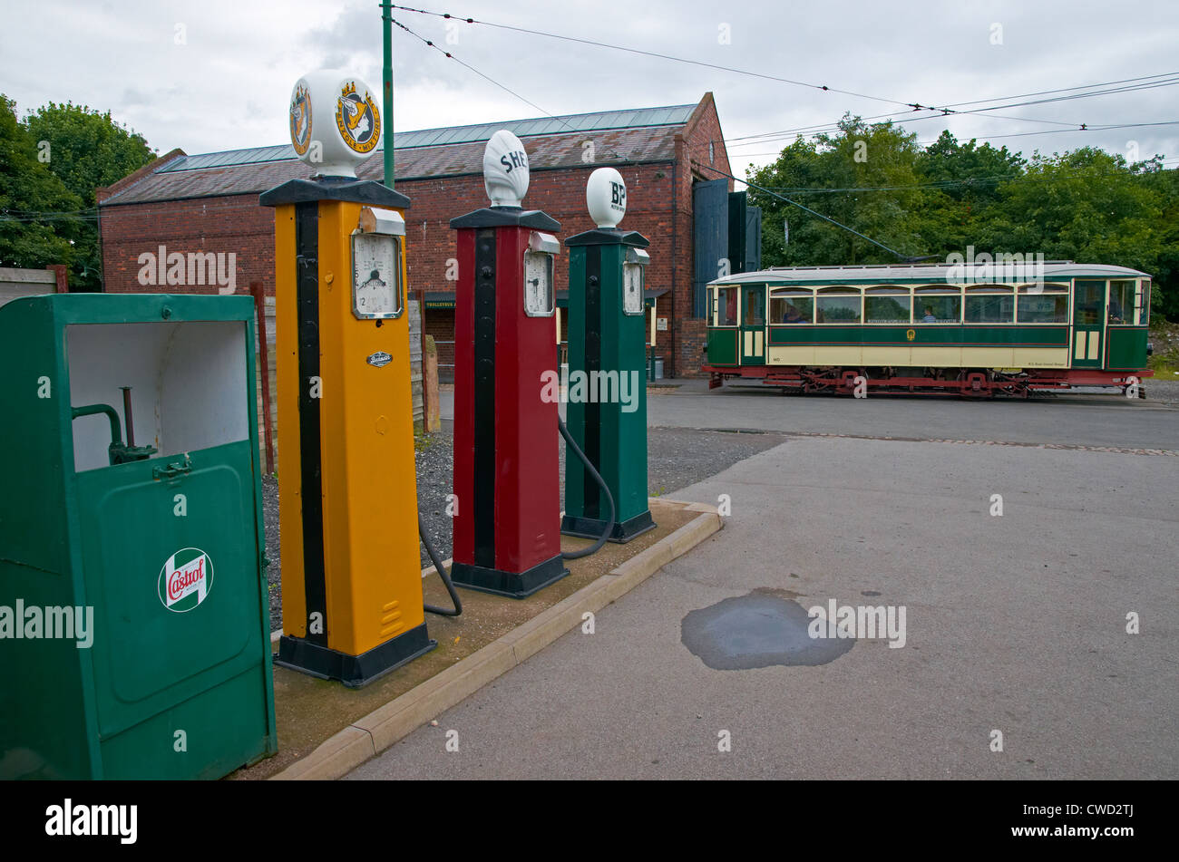 Black Country Living Museum, Dudley, West Midlands. Garage forecourt with petrol pumps. Tram & tram depot beyond. Stock Photo