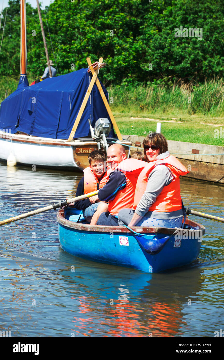 A Young family enjoy taking a rowing boat out on the Norfolk Broads