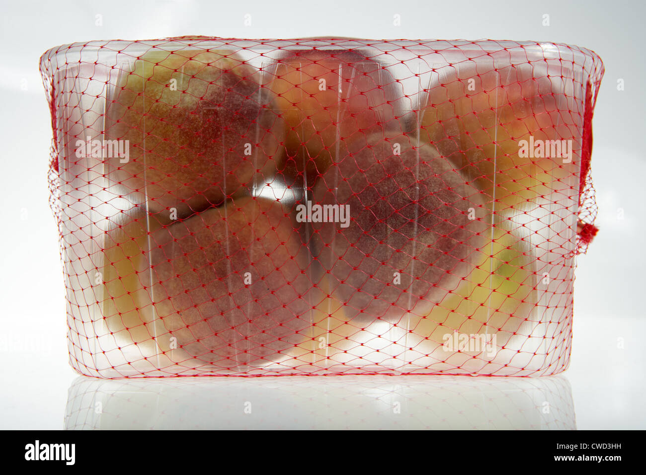 Spanish peaches in a plastic container frame covered by a red net Stock