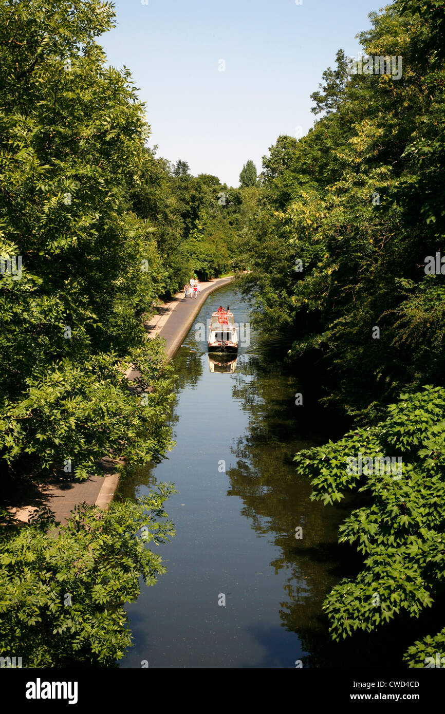 Canal boat sailing along the Regent's Canal in Regent's Park, London, UK Stock Photo