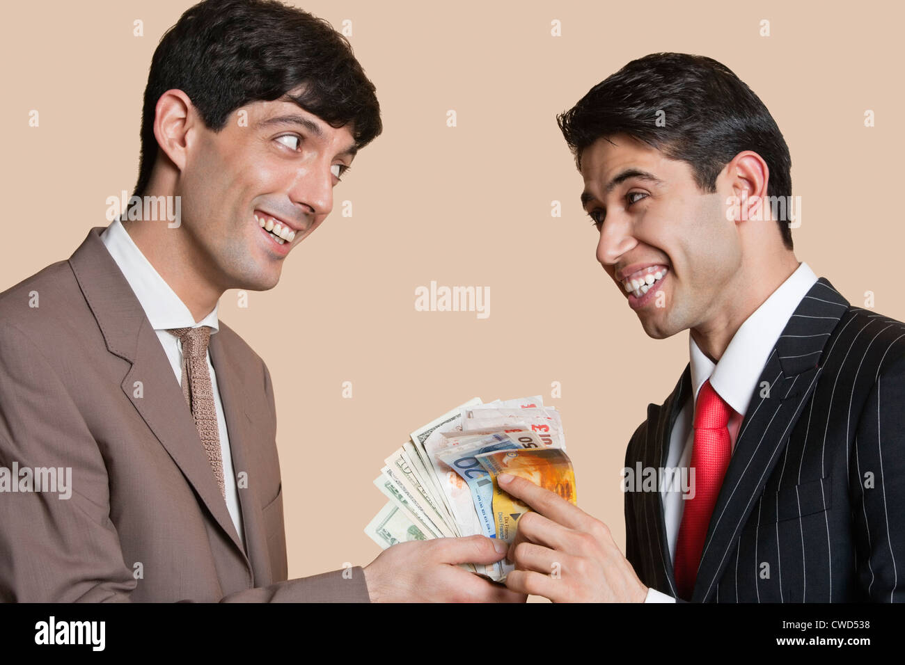 Young businessmen smiling while looking at each other with Euros in hand Stock Photo