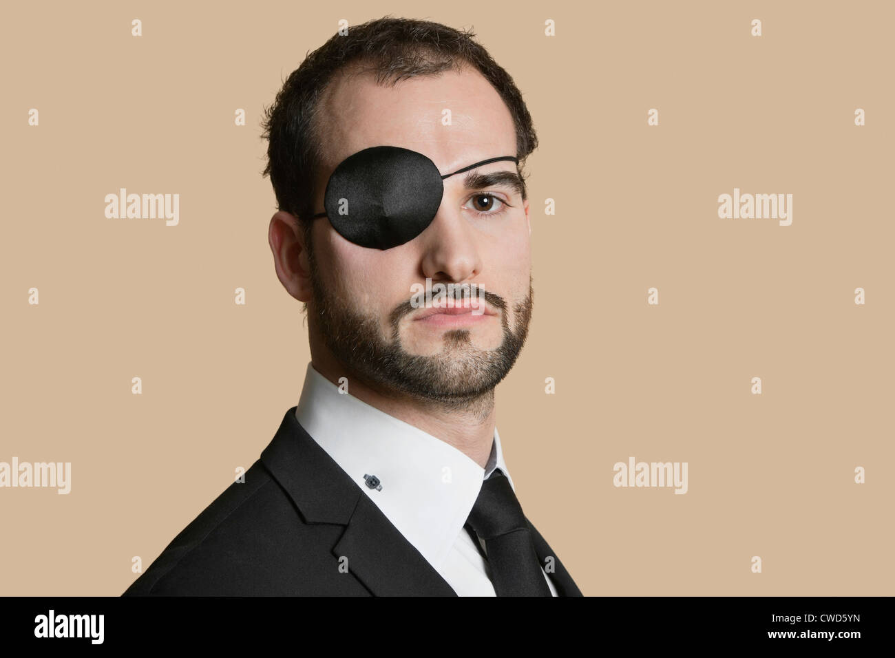 Portrait of a young businessman with eye patch over colored background Stock Photo