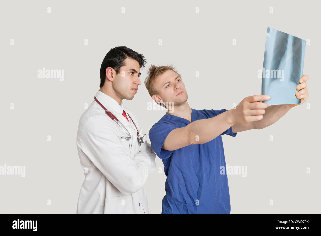 Medical professionals looking at chest x-ray over light gray background Stock Photo