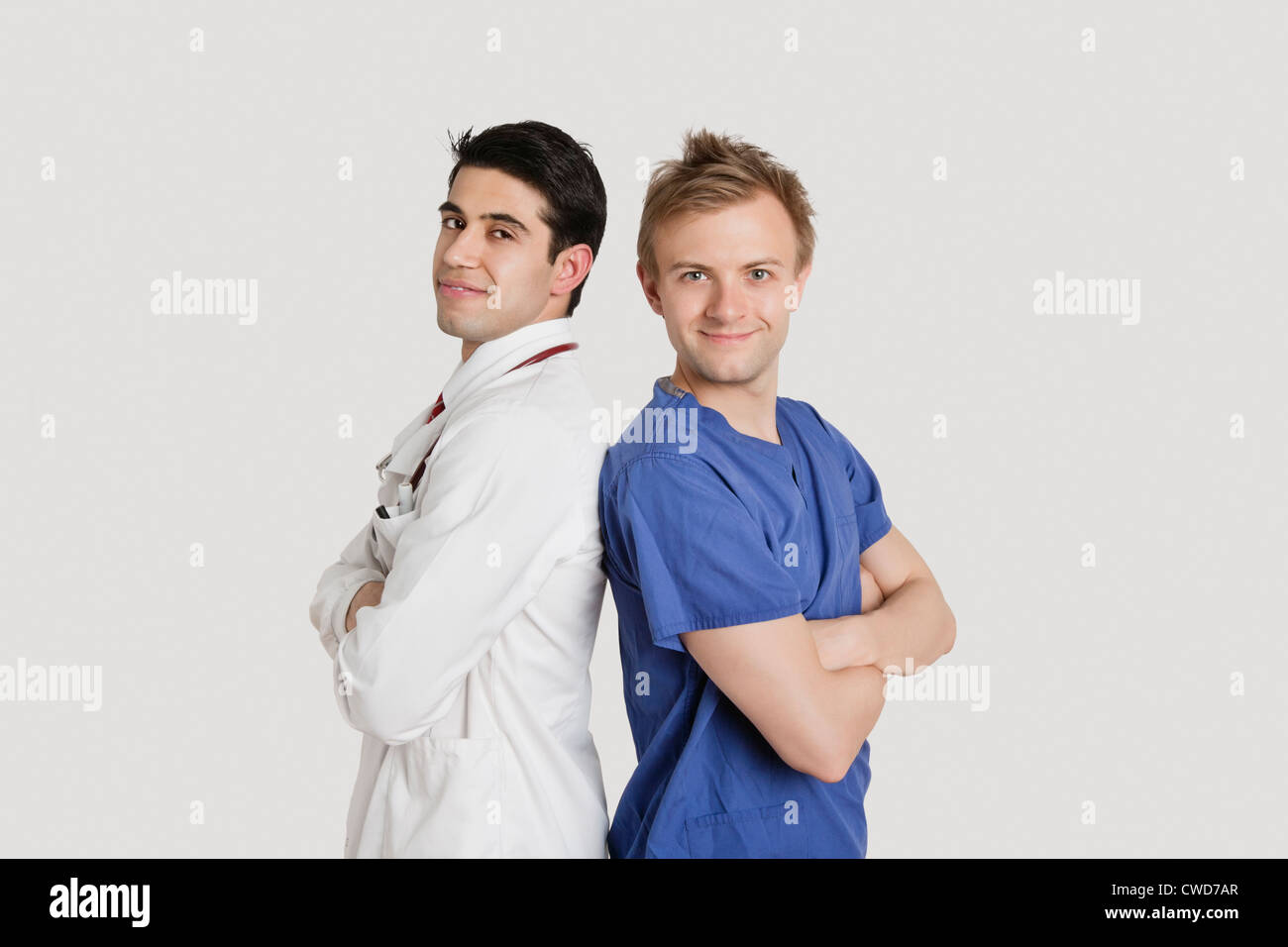 Portrait of healthcare professionals standing back to back over light gray background Stock Photo