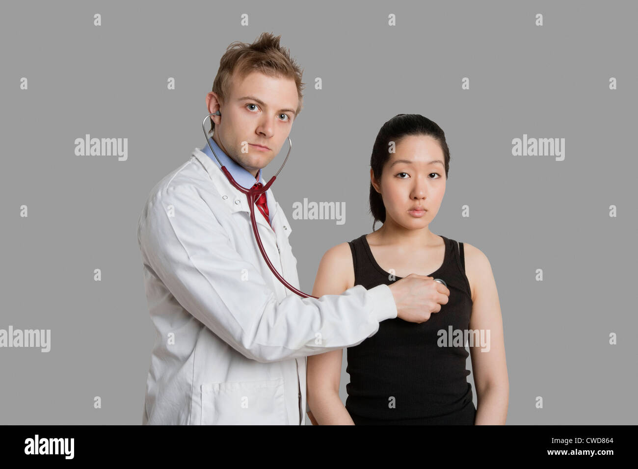 Doctor examining female patient with stethoscope Stock Photo - Alamy