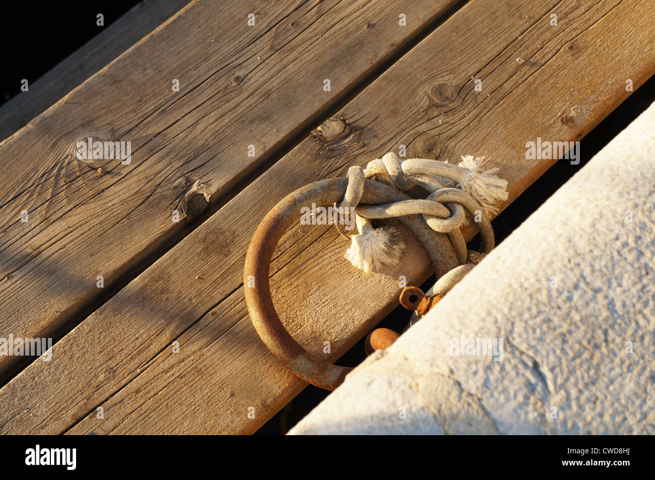 Anchoring ring with knot on a wooden wharf Stock Photo