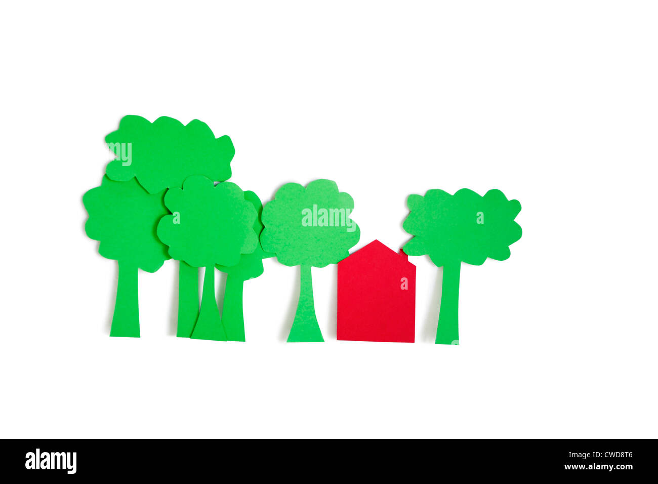 Paper cut outs of trees with a residential house over white background Stock Photo