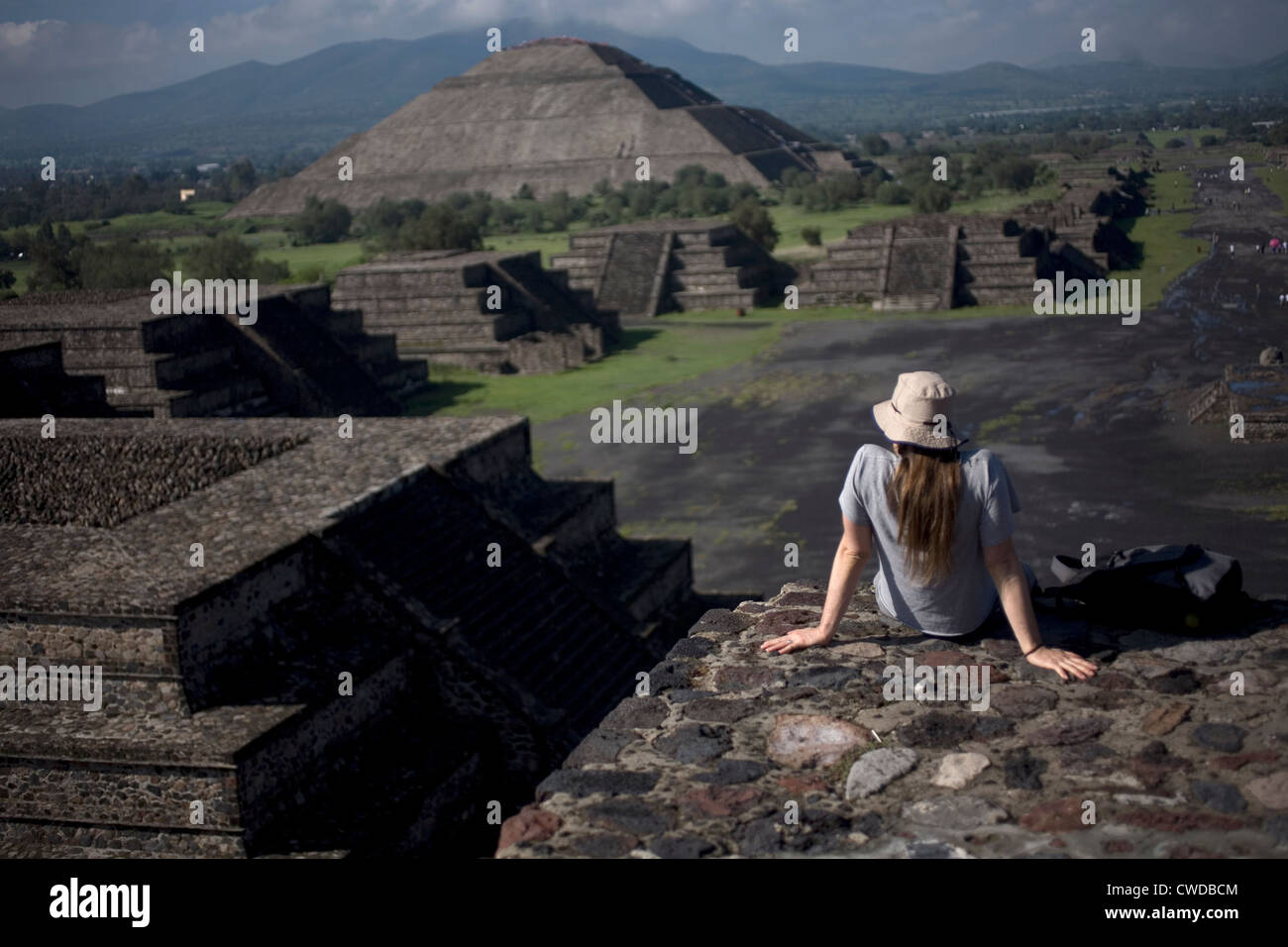 A woman looks at the Pyramid of the Sun, back left, from the Pyramid of the Moon in Teotihuacan Stock Photo