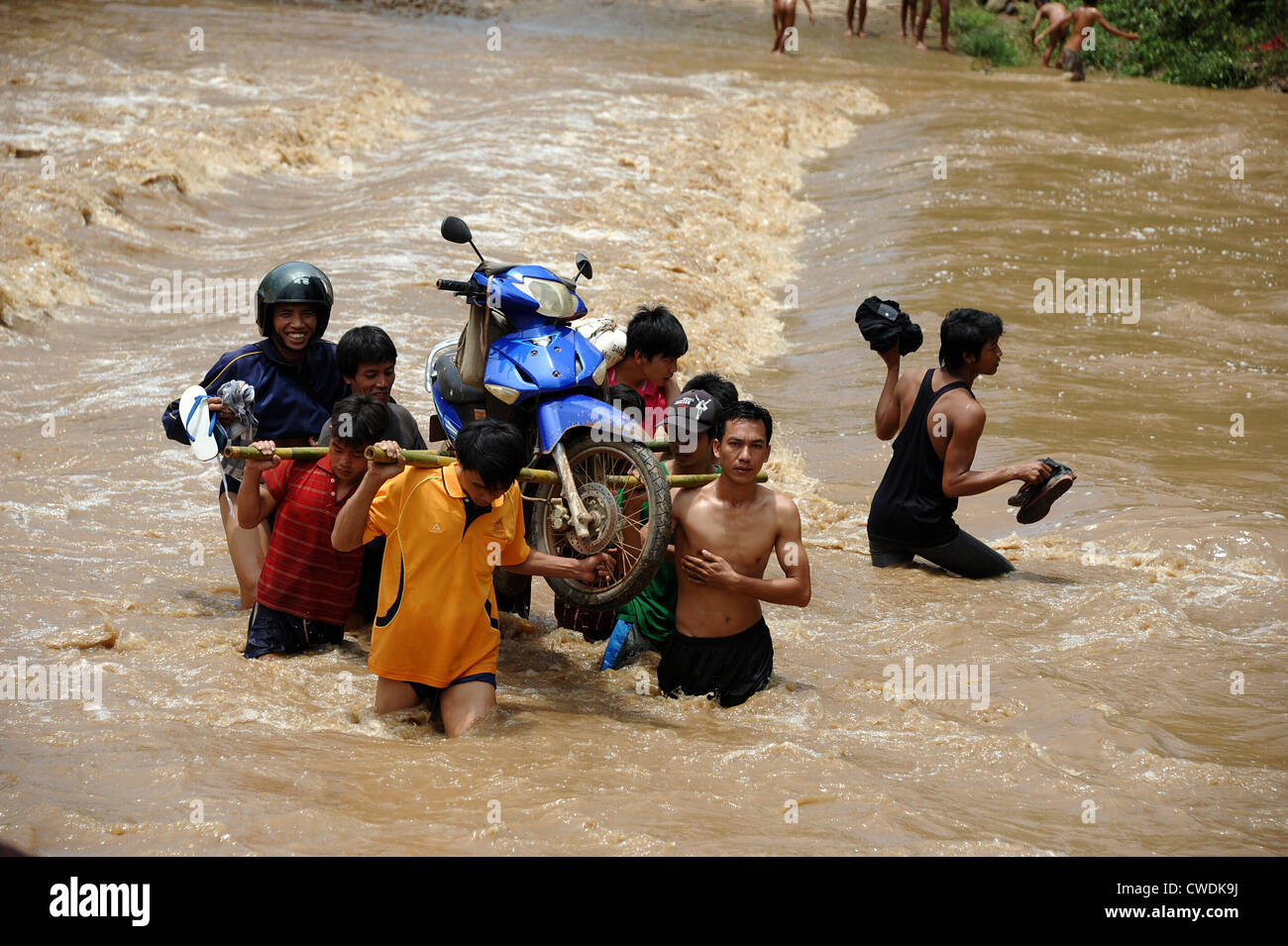 Villagers walking through flooded river in Banthapho village near Luang Prabang, Laos. Stock Photo