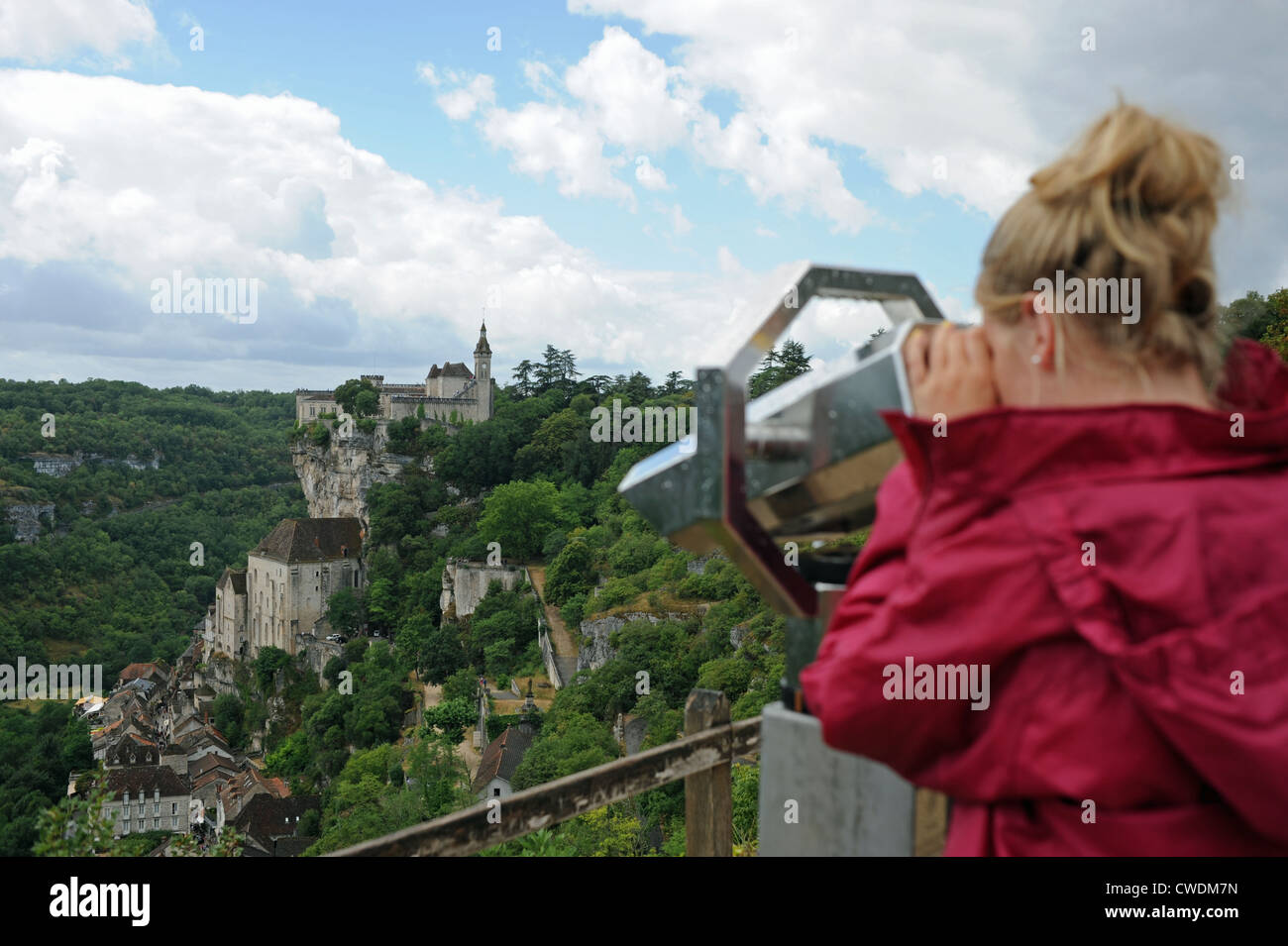 Girl looking through binoculars at historic and medieval town of Rocamadour in the Lot Region of South West France Europe Stock Photo