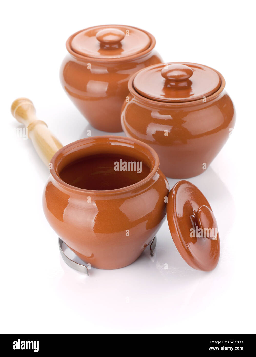 Three clay pots and holder. Isolated on white background Stock Photo