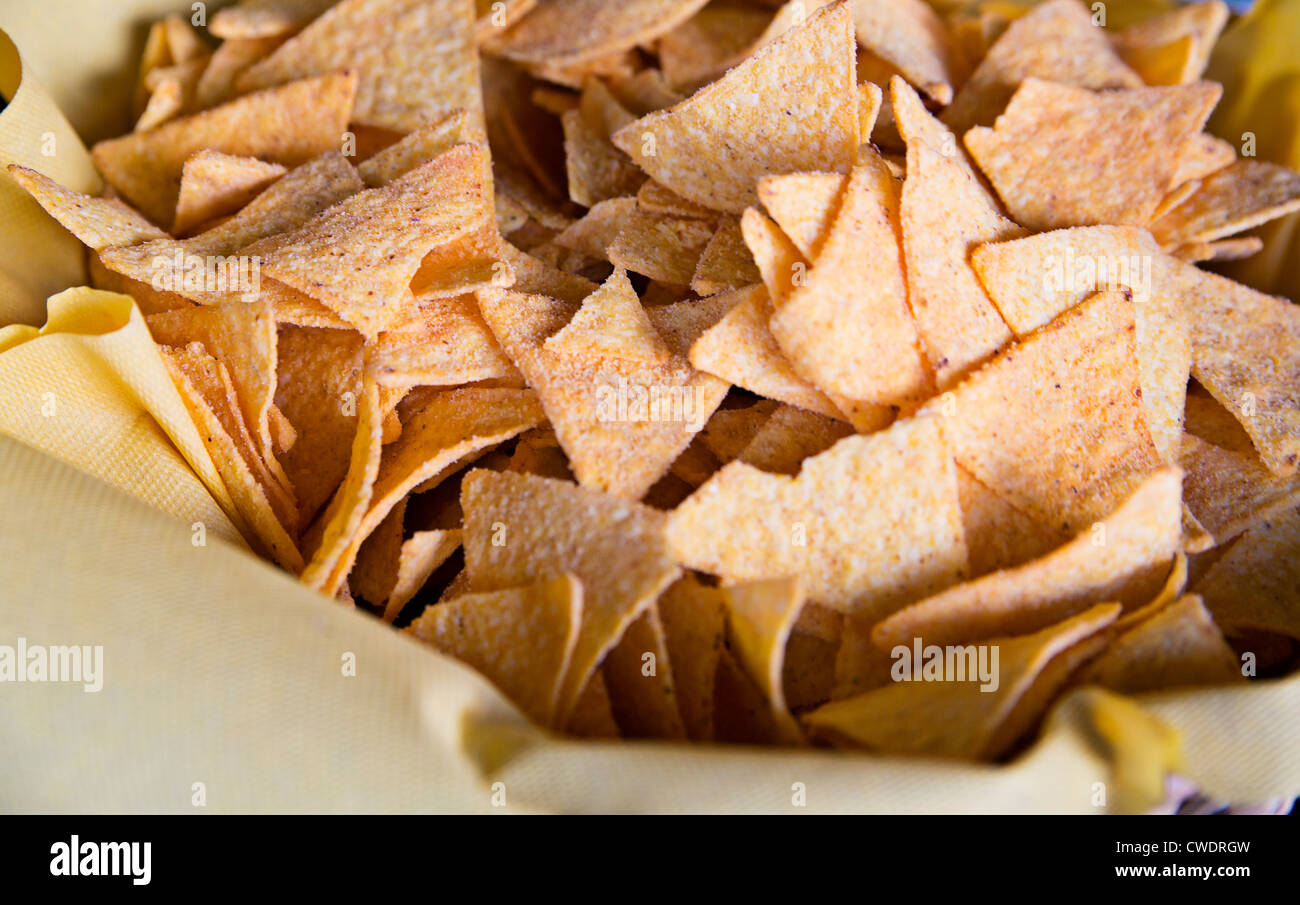 Triangular chips salted and spiced are in dish hires stock photography
