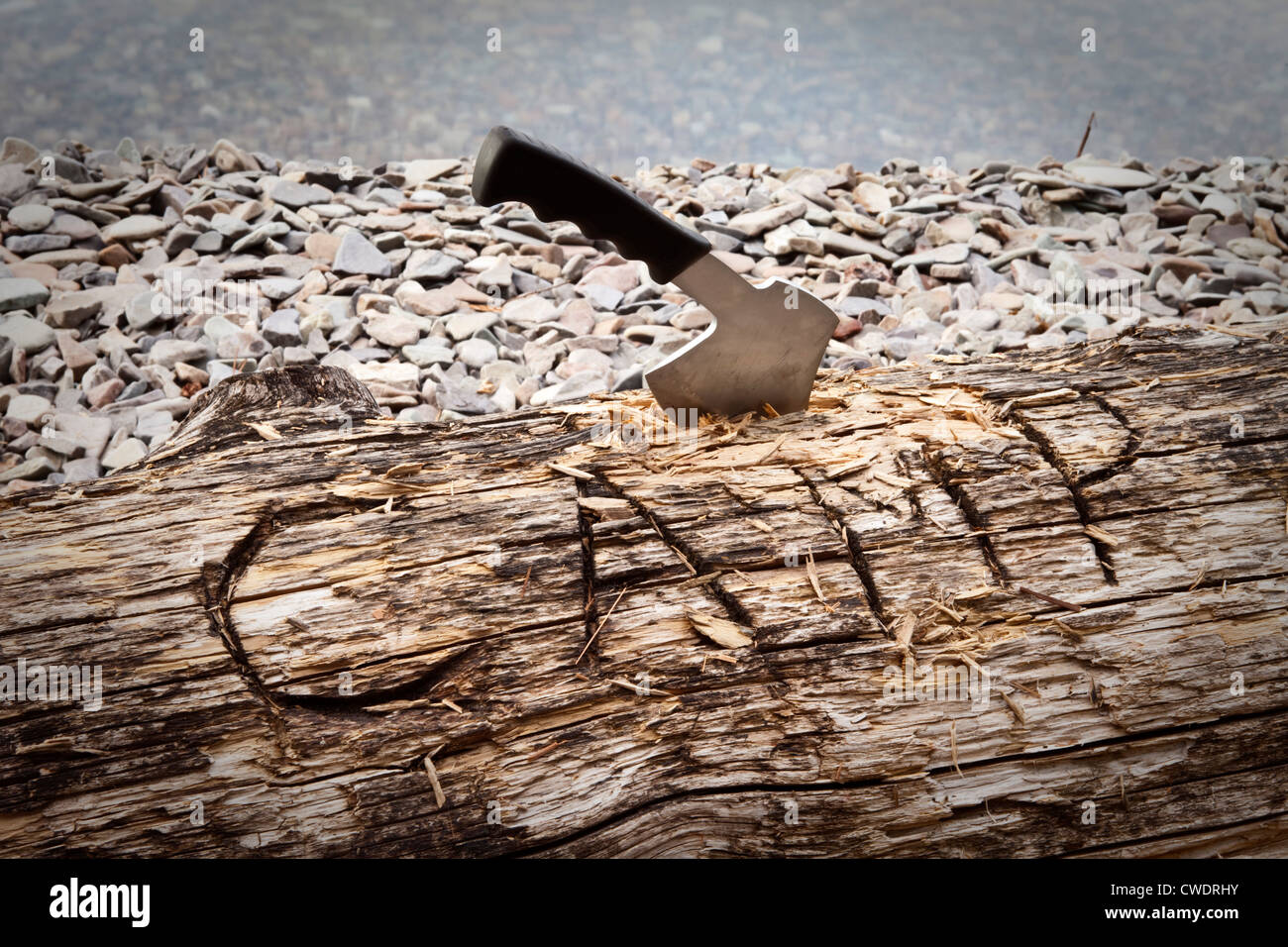 A hatchet burried into a log that reads camp next to a lake in Idaho. Stock Photo