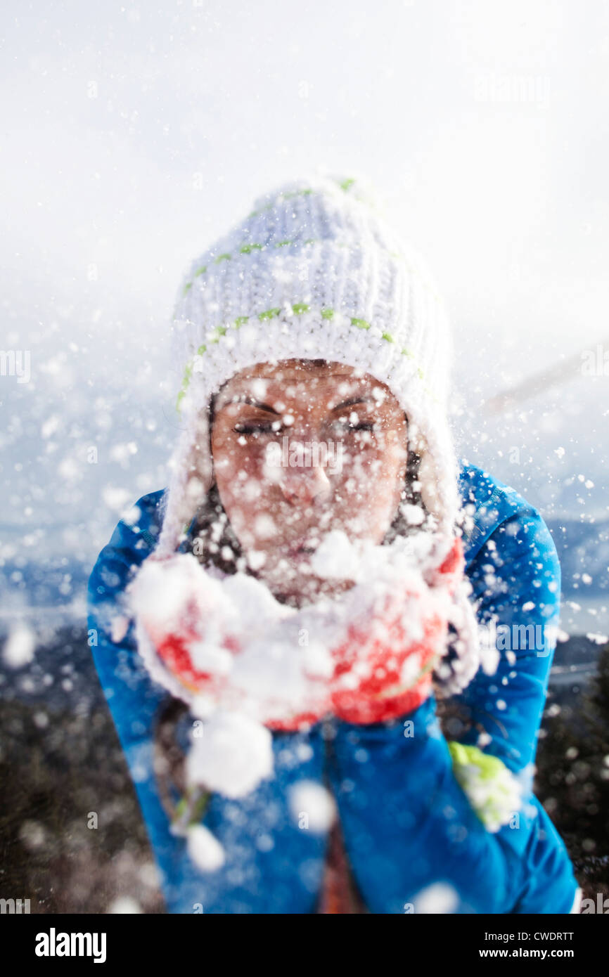 A beautiful young woman blowing snow on a winter hike in Idaho. Stock Photo
