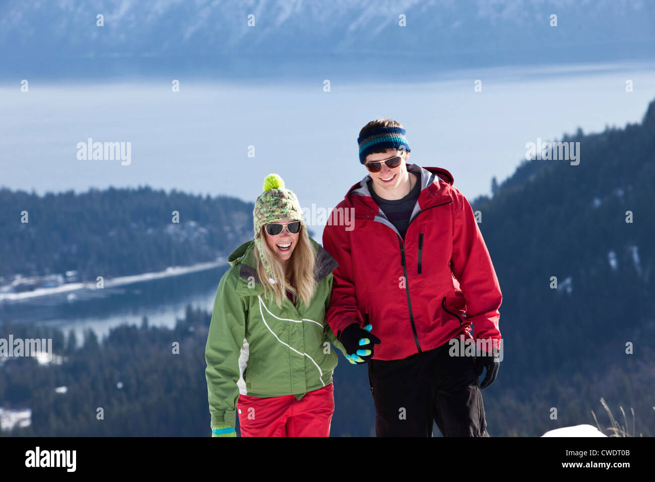 Two young adults smile while snowshoeing on a beautiful winter day in Idaho. Stock Photo