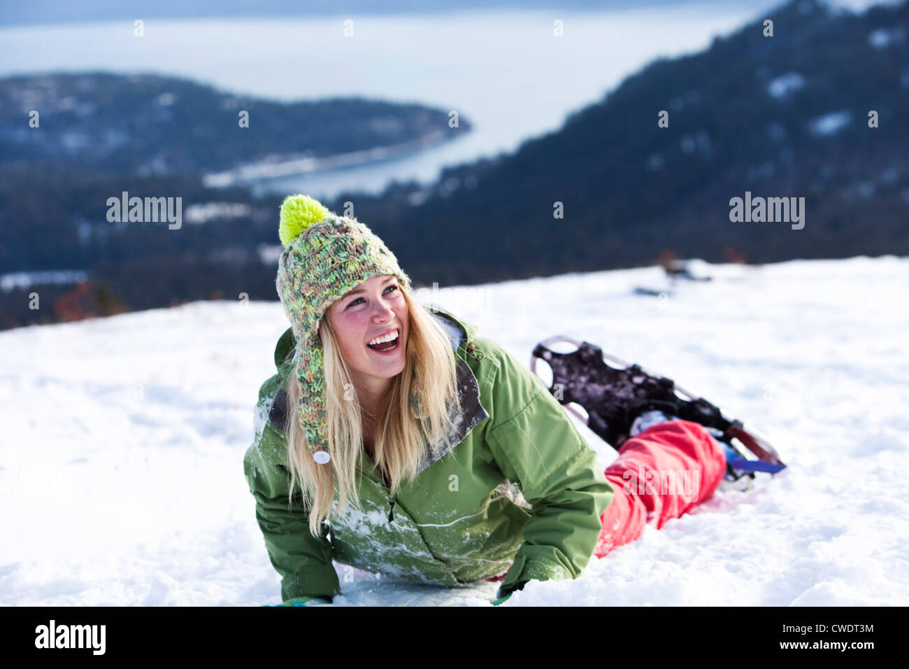 A athletic young woman laughs while snowshoeing in Idaho. Stock Photo