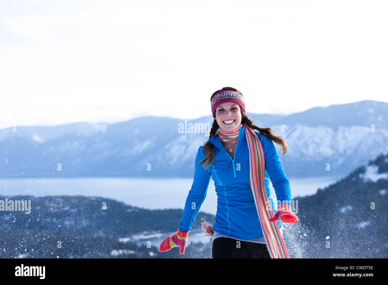 A athletic young woman laughs while snowshoeing in Idaho. Stock Photo