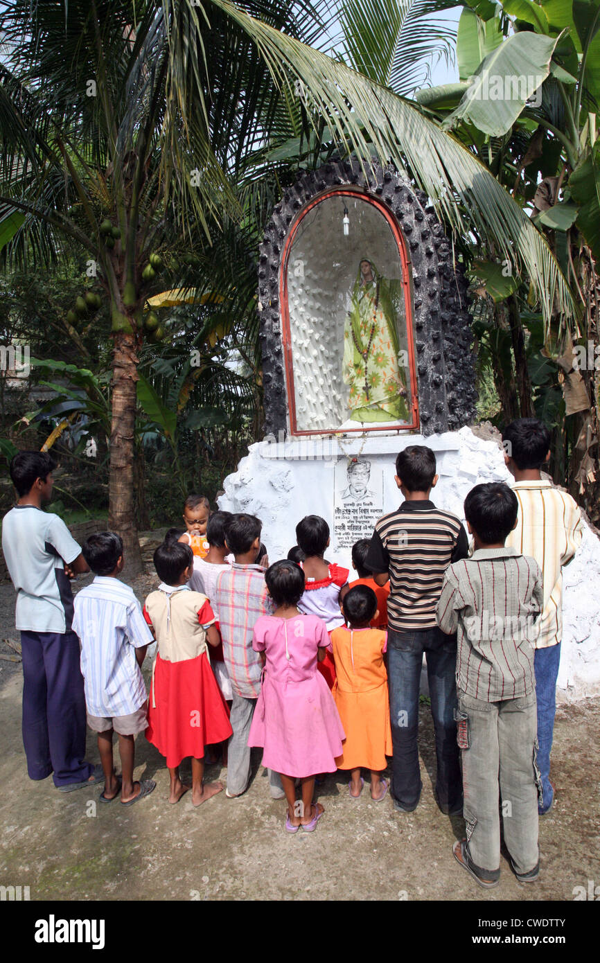 A group of young Bengali Catholics pray before a statue of the Virgin Mary in Basanti, West Bengal, India Stock Photo