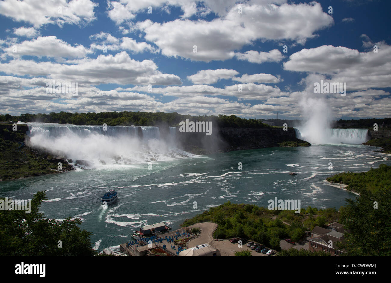 Niagara Falls, Ontario - Niagara Falls. The Maid of the Mist carries tourists wearing blue raincoats to the edge of the falls. Stock Photo