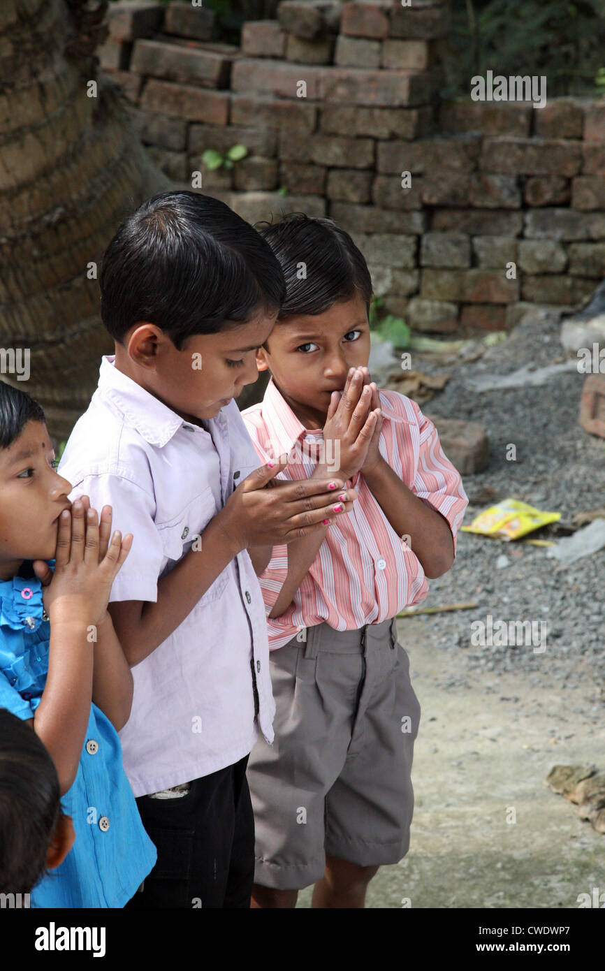 A group of young Bengali Catholics pray before a statue of the Virgin