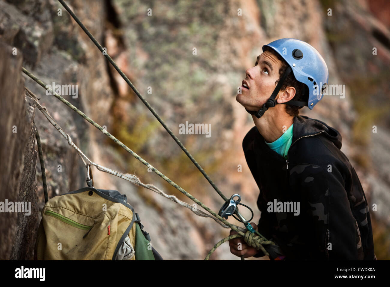 A athletic man rock climbing belays his partner in Montana. Stock Photo
