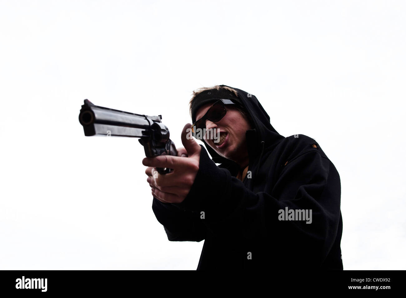 A young man points his large hand gun in Montana. Stock Photo