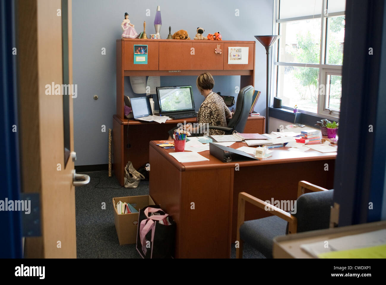 Female white principal of elementary school works at computer in office before start of new school year in Austin, Texas Stock Photo
