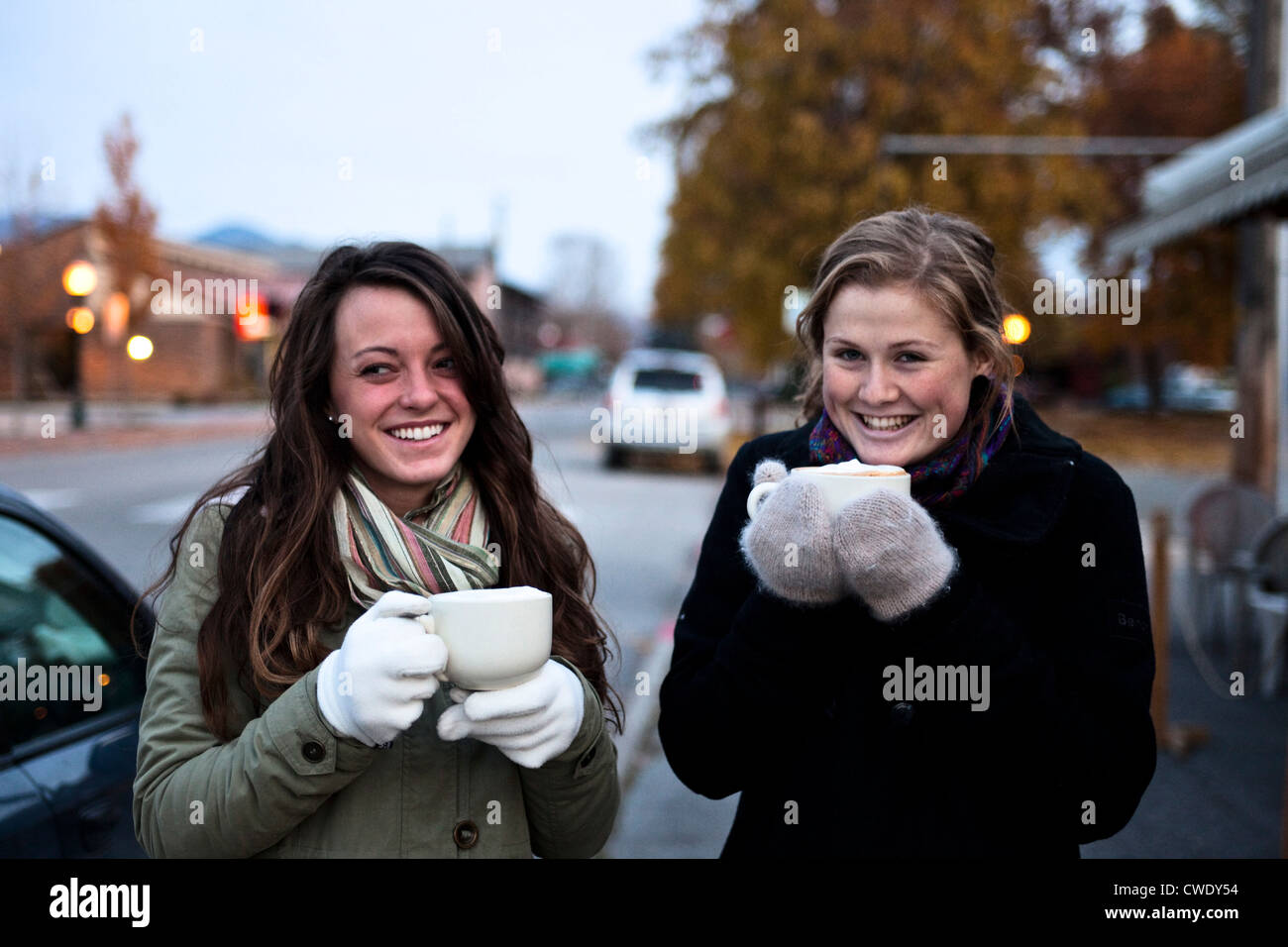 Two athletic young women smiling drink coffee in the early morning in Idaho. Stock Photo