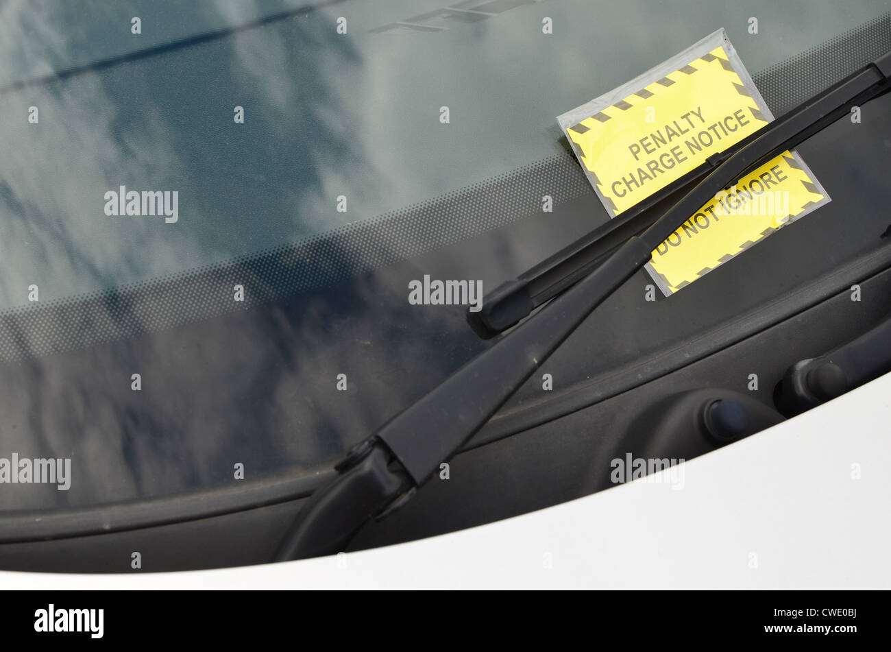 Penalty Charge Notice under the windscreen wiper of a silver car. Stock Photo