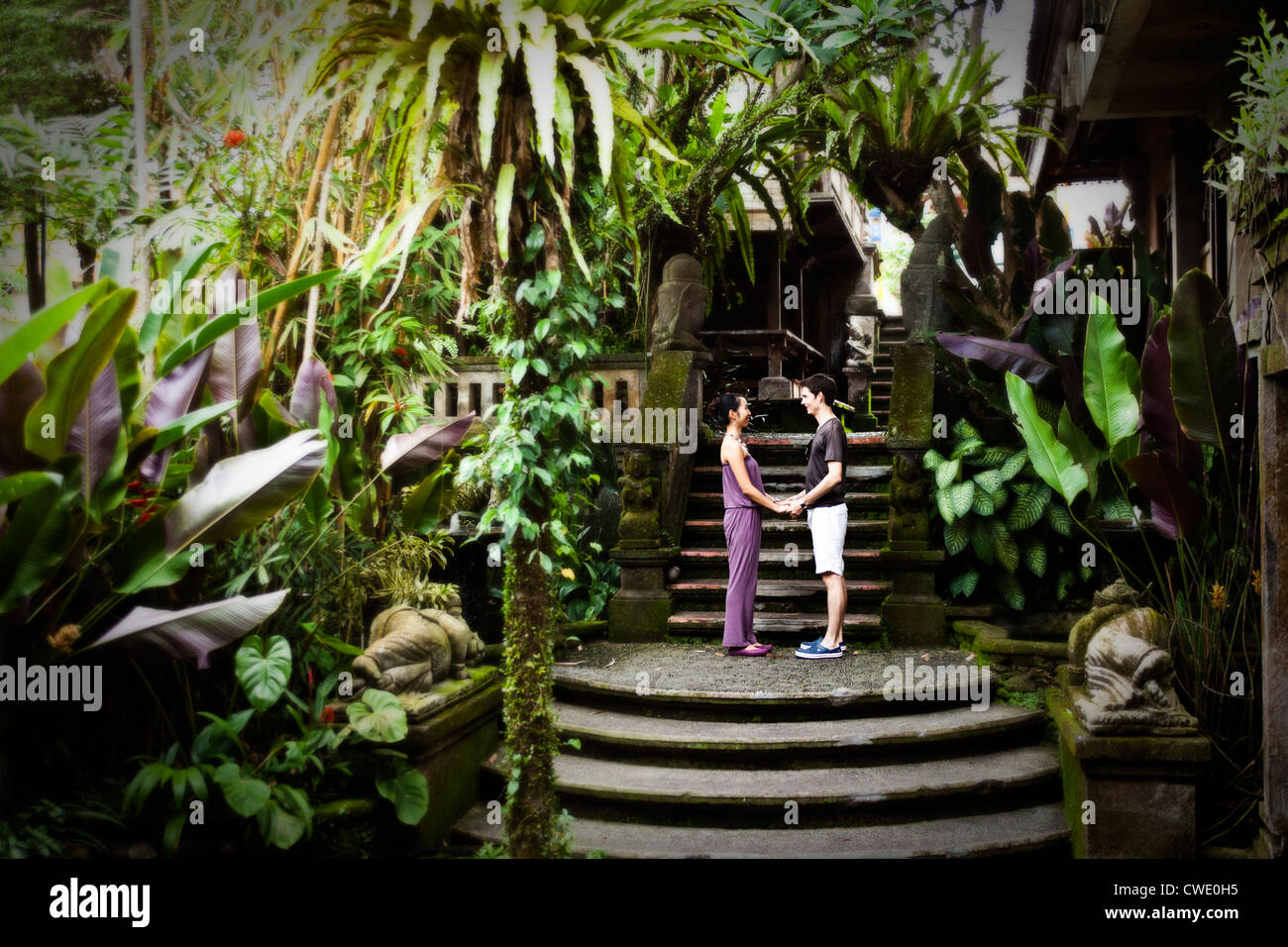 A happy married couple holding hands in a lush jungle setting in Bali, Indonesia. Stock Photo