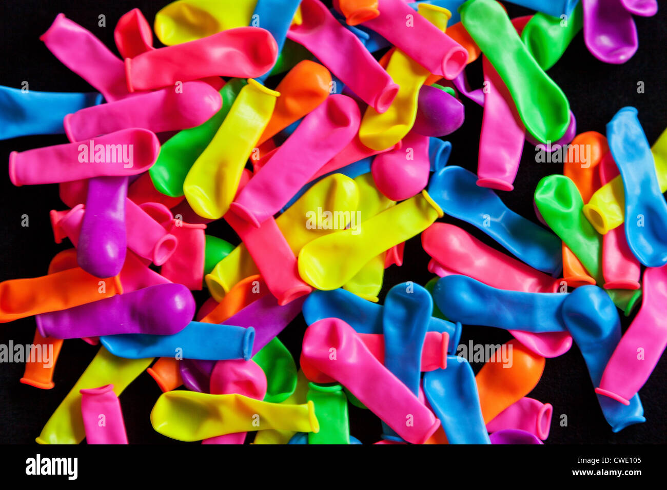 A pile of deflated balloons on a black background, Stock Photo
