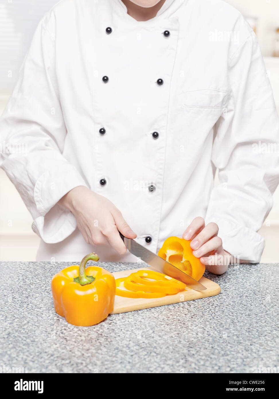 chef cutting bell peppers on board Stock Photo