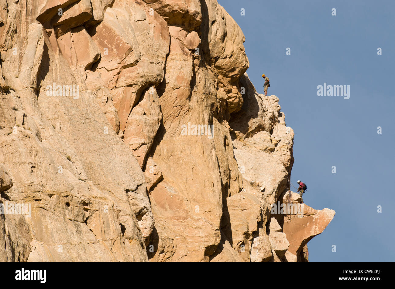 Two men rock climbing a sandstone prow in the San Rafael Swell, Green River, Utah. Stock Photo