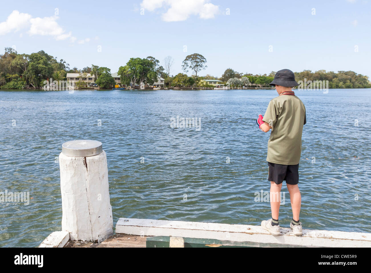 Boy fishing from jetty on Noosa River, Tewantin, Sunshine Coast