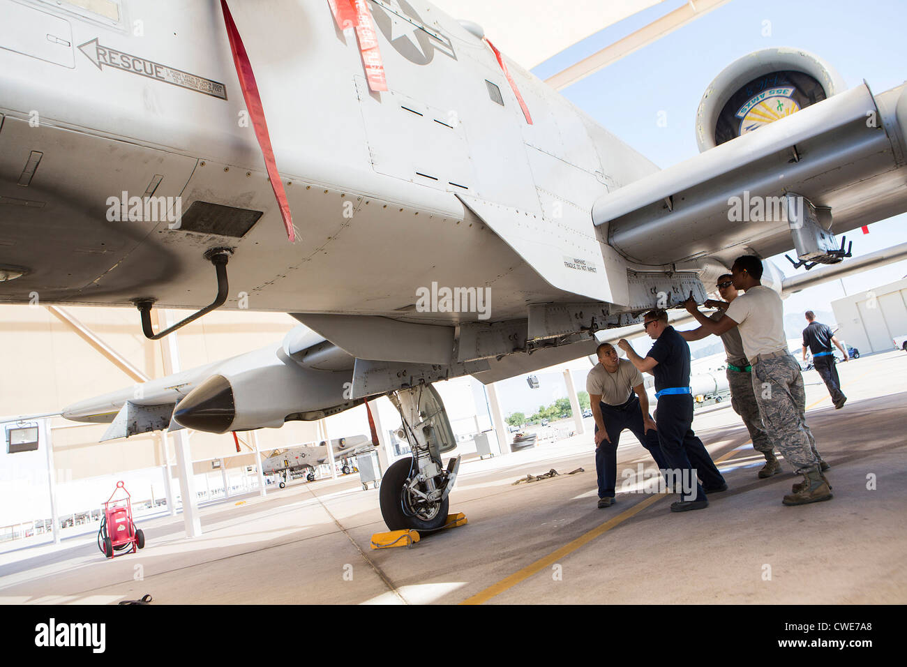 Airmen attach a external fuel tank to an A10 Thunderbolt from the
