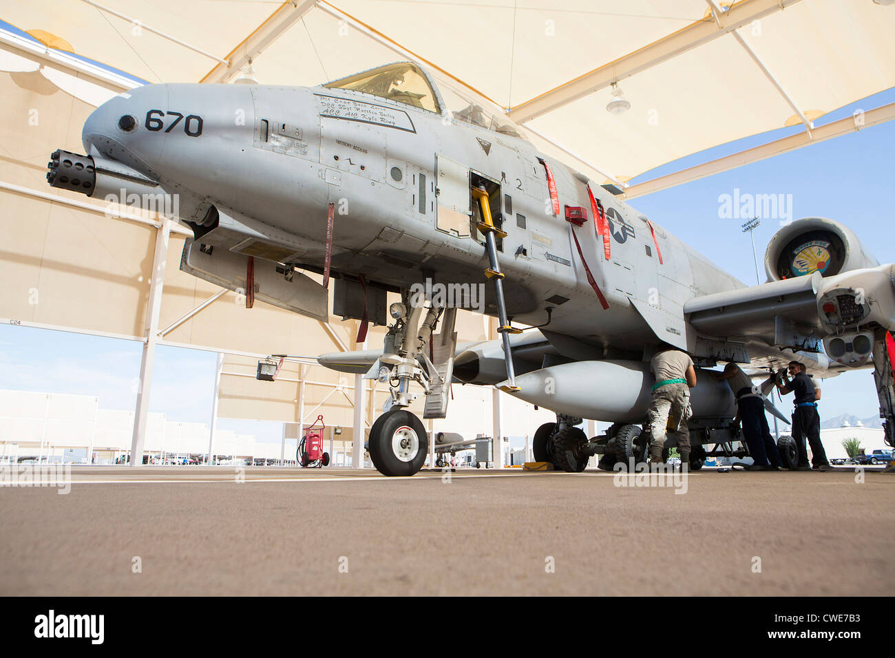 Airmen attach a external fuel tank to an A10 Thunderbolt from the