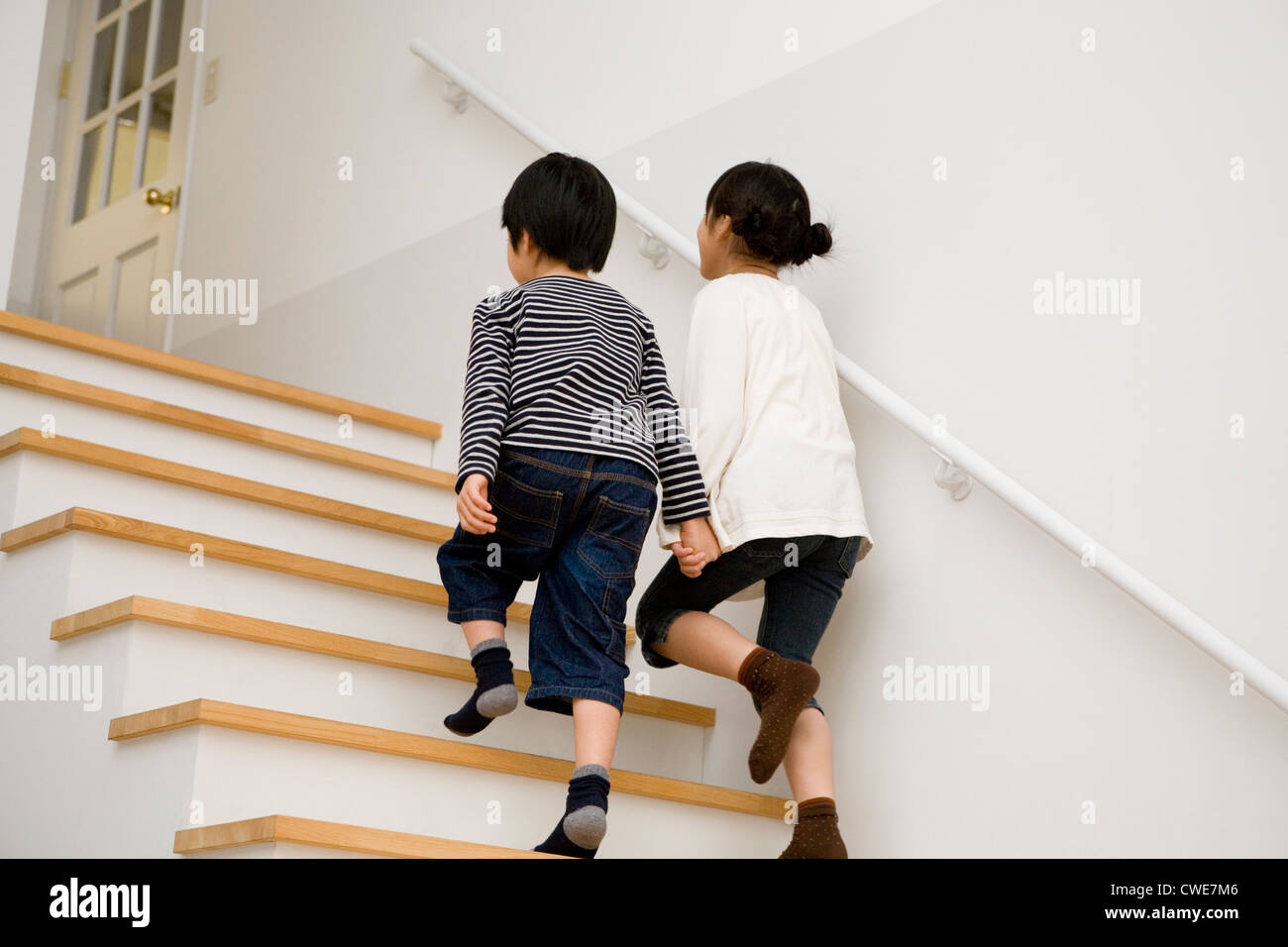 Two kids climbing up stairs hi res stock photography and images Alamy