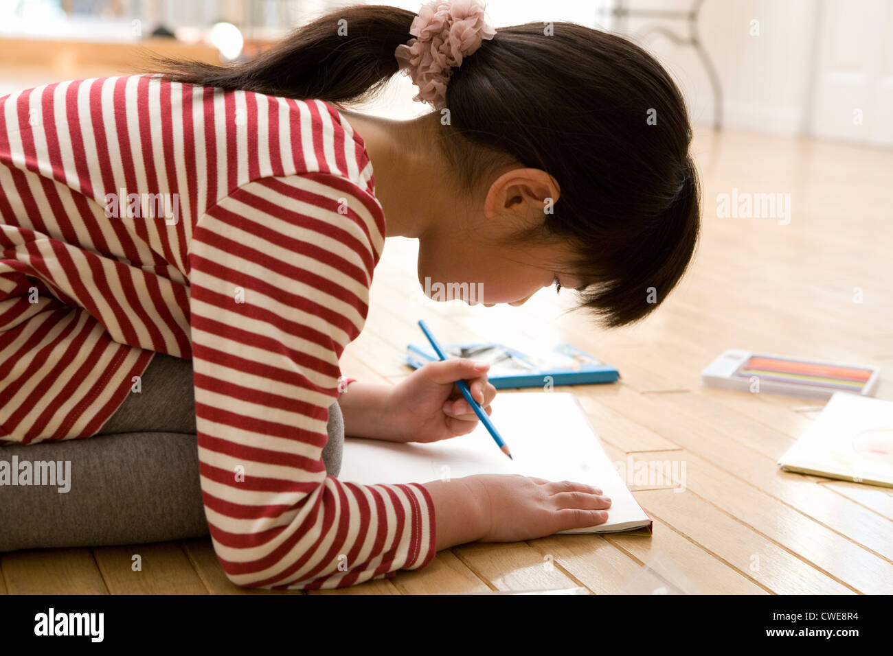 Girl kneeling drawing picture hi-res stock photography and images - Alamy