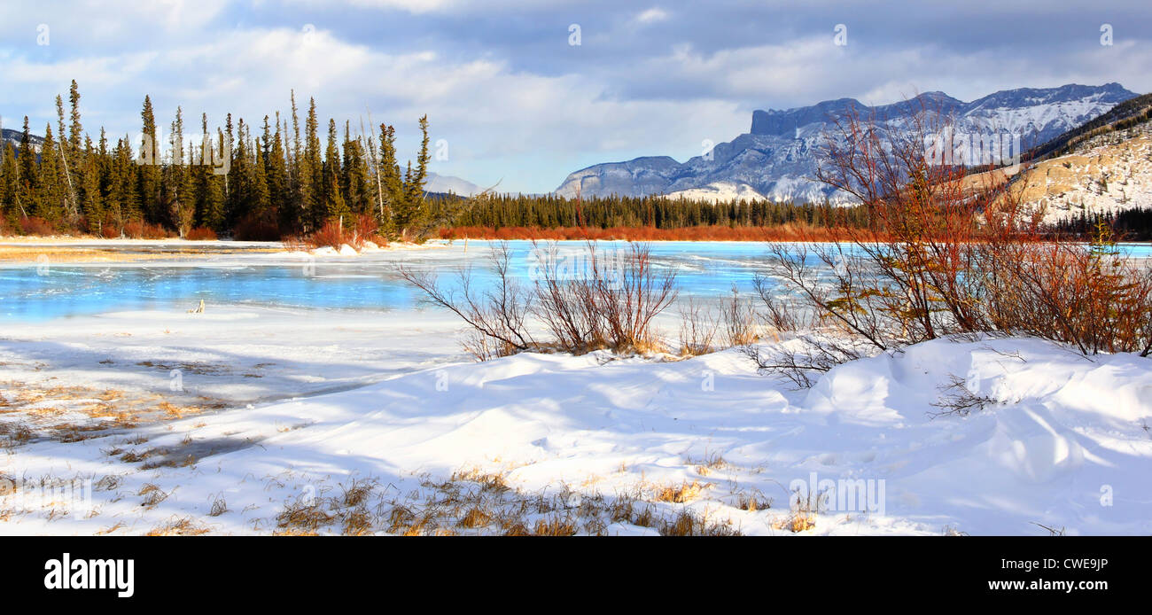 40,931.06149 Breathtaking & freezing cold winter landscape with fresh snow, frozen icy lake, mountains, bright blue ice, red bark brush Stock Photo