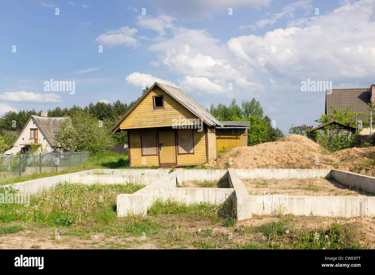 The crisis in agriculture European village building construction. Old yellow curve rickety wooden abandoned no name mass product Stock Photo