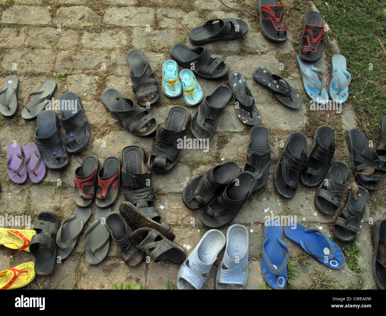 Shoes in front of the Catholic Church in India in all the temples enters  barefoot Stock Photo - Alamy